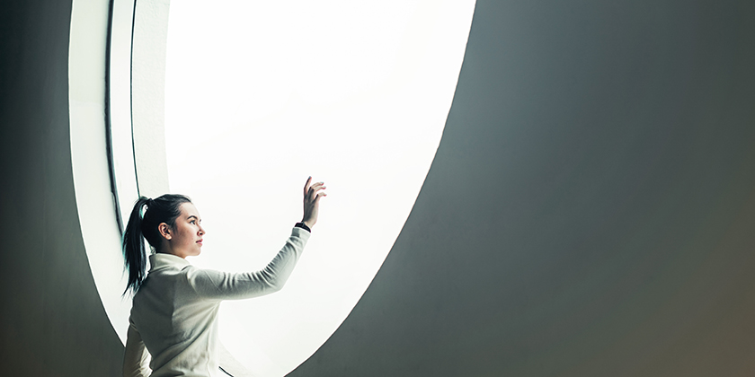 Woman looking out of a round window