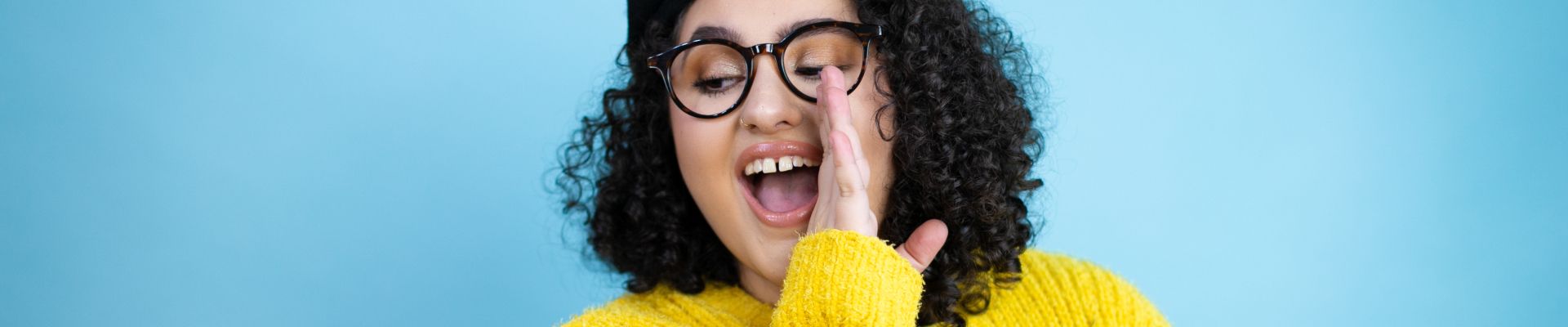 Woman in glasses whispering