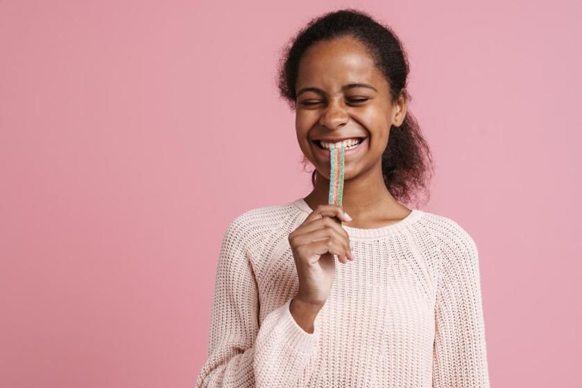Brunette black girl smiling while eating candy .jpg