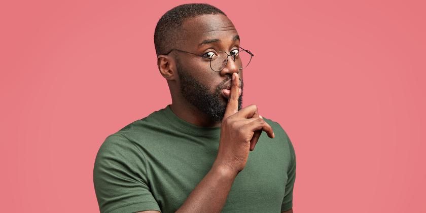 Man in glasses putting finger to his mouthMan in glasses putting finger to his mouth 840x420