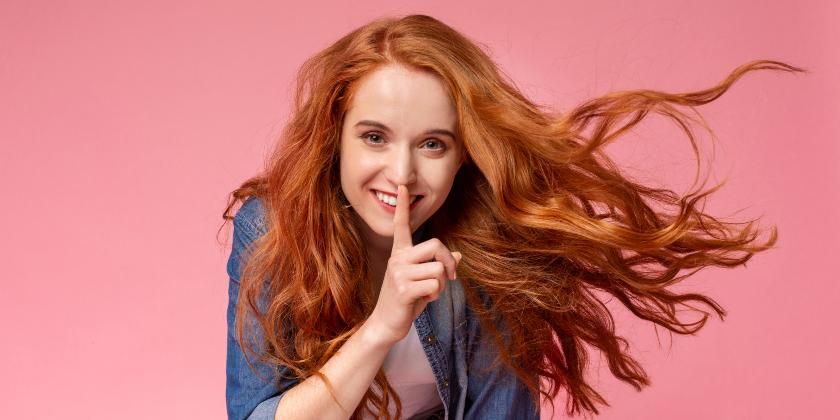 Woman with red hair whispering