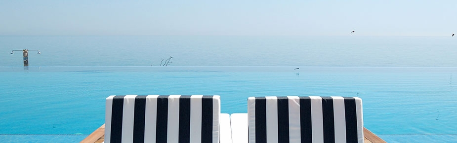 striped sunbeds on an infinity pool