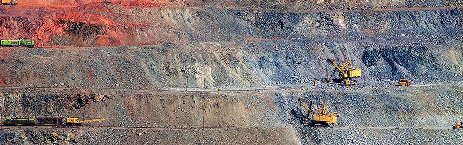 excavators working on an open mine pit