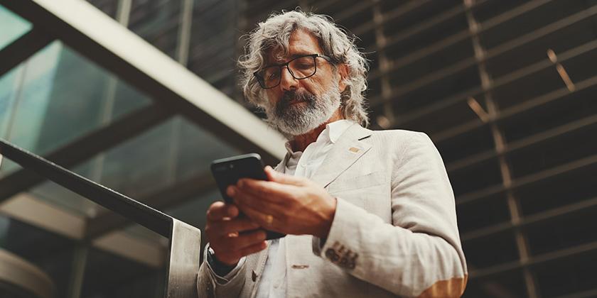 businessman with beard on smartphone 840x420.jpg