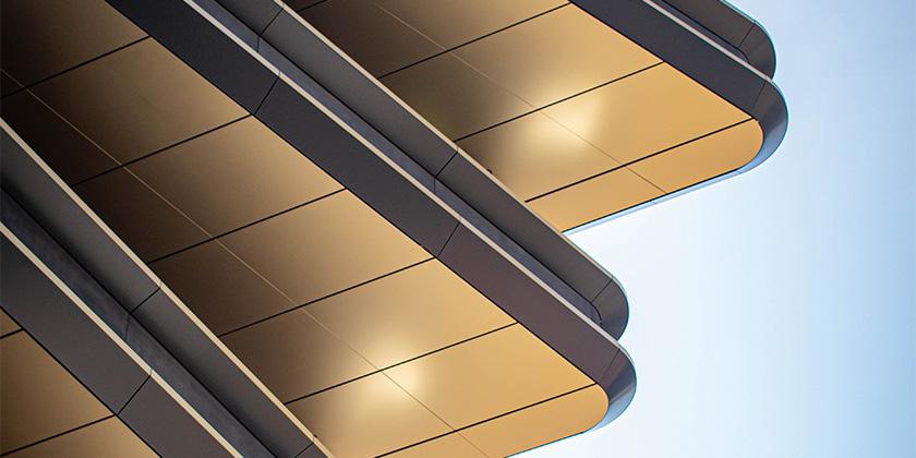 gold tiered skyscraper against blue sky 840x420.jpg