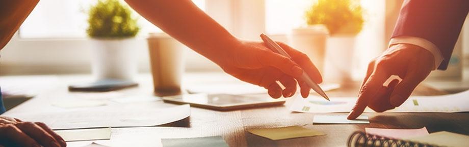 two men pointing to paperwork