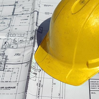 yellow hard hat lying on blue print