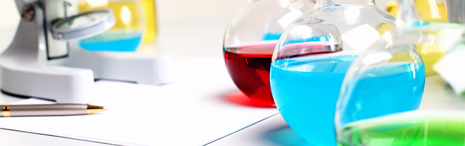 microscope with bottles of chemicals in forefront