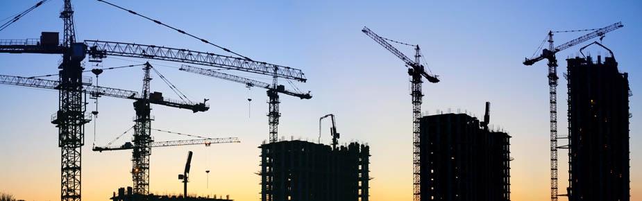 Silhouette of cranes against blue skyline