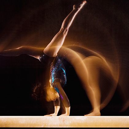 gymnast doing cartwheel on balance beam