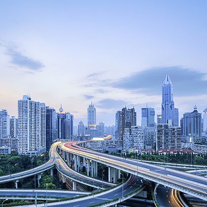 highway intersection with modern city skyline at dusk in shanghai 的照片