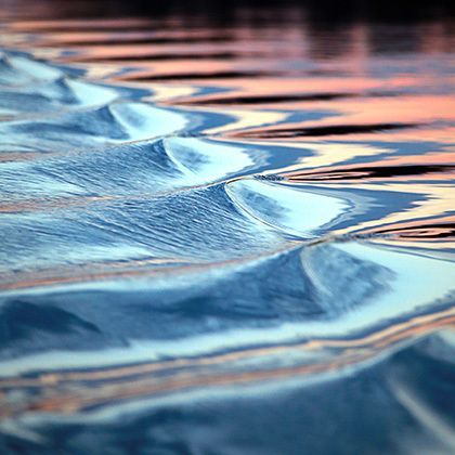 closeup amazing wavy trace of the boat on the river at sunset