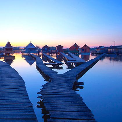 wooden houses in the lake at sunset