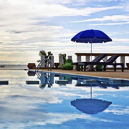 swimming pool with blue parasol at sunset