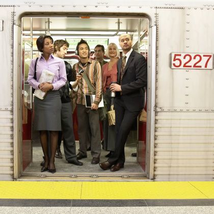 medium group of people standing in subway train doorway