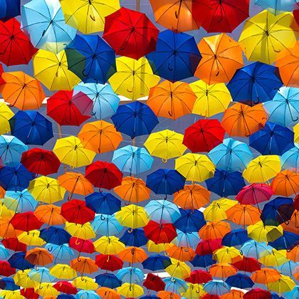 lots of umbrellas colouring the skye in the city of agueda, portugal