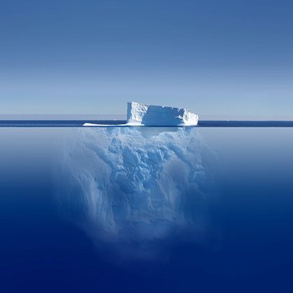 view at transparent water with partly under water iceberg in deep blue ocean 的照片
