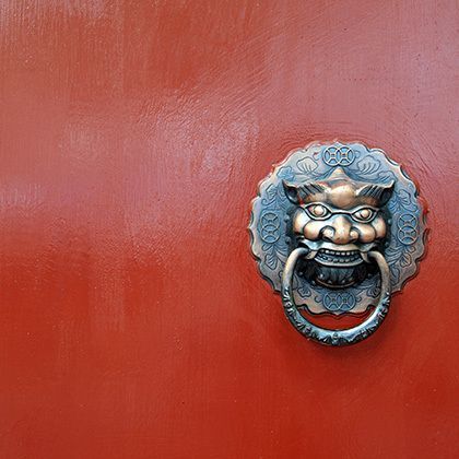 chinese vintage lion on red door 的照片