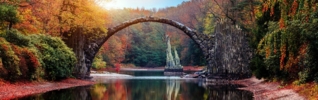 autumnal picture of a bridge going across water