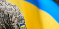 Ukrainian soldier in front on Ukrainian flag