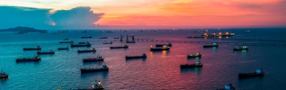 Oil tanker ship loading in port at twilight 925x290