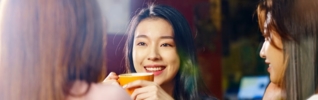 smiling woman drinking from yellow cup