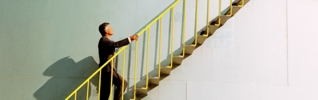 side profile of a man climbing the ladder of an industrial silo