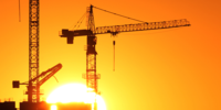 Construction cranes at sunrise