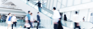 blurred shoppers going up an escalator