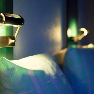 closeup of pillows on lighted bed in a hotel 