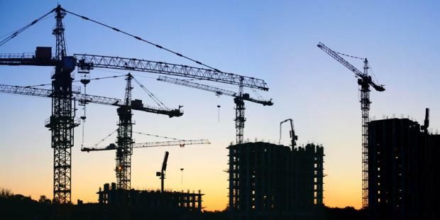 Silhouette of cranes against blue skyline