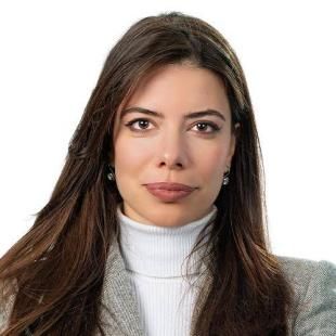 A portrait of Doris Stepanovic - she has long brown hair and a white swater and grey blazer on.