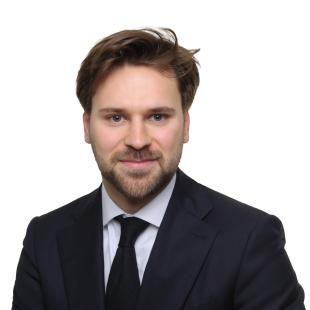 Portrait professionnel de Baumann Hubert en tenue formelle, portant costume et cravate sur fond neutre