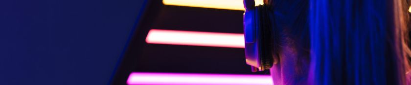 woman wearing headphones over multicolored neon lights1920x400.jpg