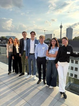 Die Praktikantinnen und Praktikanten stehen in einer Reihe auf der Terrasse des D&uuml;sseldorfer B&uuml;ros