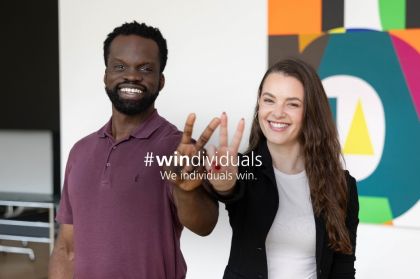 Two individuals raise their hands, showcasing the word "windividuals" prominently between them.